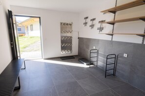 Ein modernes Badezimmer mit Dusche, Handtuchhalter und einer Metallregaleinheit.