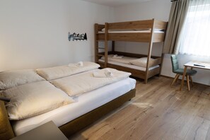 Een kamer met een stapelbed, een bureau en een stoel.