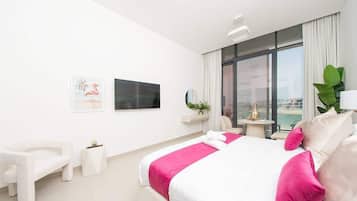 Une chambre d’hôtel moderne dotée d’un grand lit, d’un coin salon, d’une petite table et d’une grande fenêtre offrant une vue agréable.