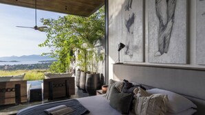 A bedroom with a large bed, a view of the outdoors, and artwork on the wall. - Villa Suwan -The Hilltop Escape Samui (Koh Samui)