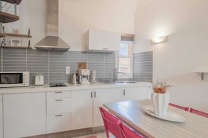 A modern kitchen with white cabinets, a microwave, a toaster, and a sink. - Charming Apartment - 1BR - 2P - Saint-tropez (Saint-Tropez)