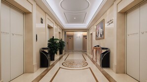 A hotel corridor with a polished floor, a central circular design, and doors on both sides. - Vienna Hotel Fuzhou Cangshan Wanda (Fuzhou)
