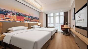A hotel room with two beds, a desk, a chair, a TV, and a large window.