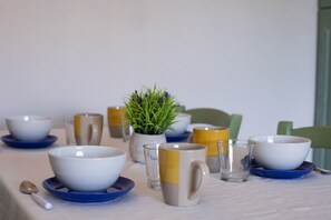 A dining table with bowls, glasses, and a potted plant. - Casa dell'Edera F2/1 by Wonderful Italy (San Teodoro)
