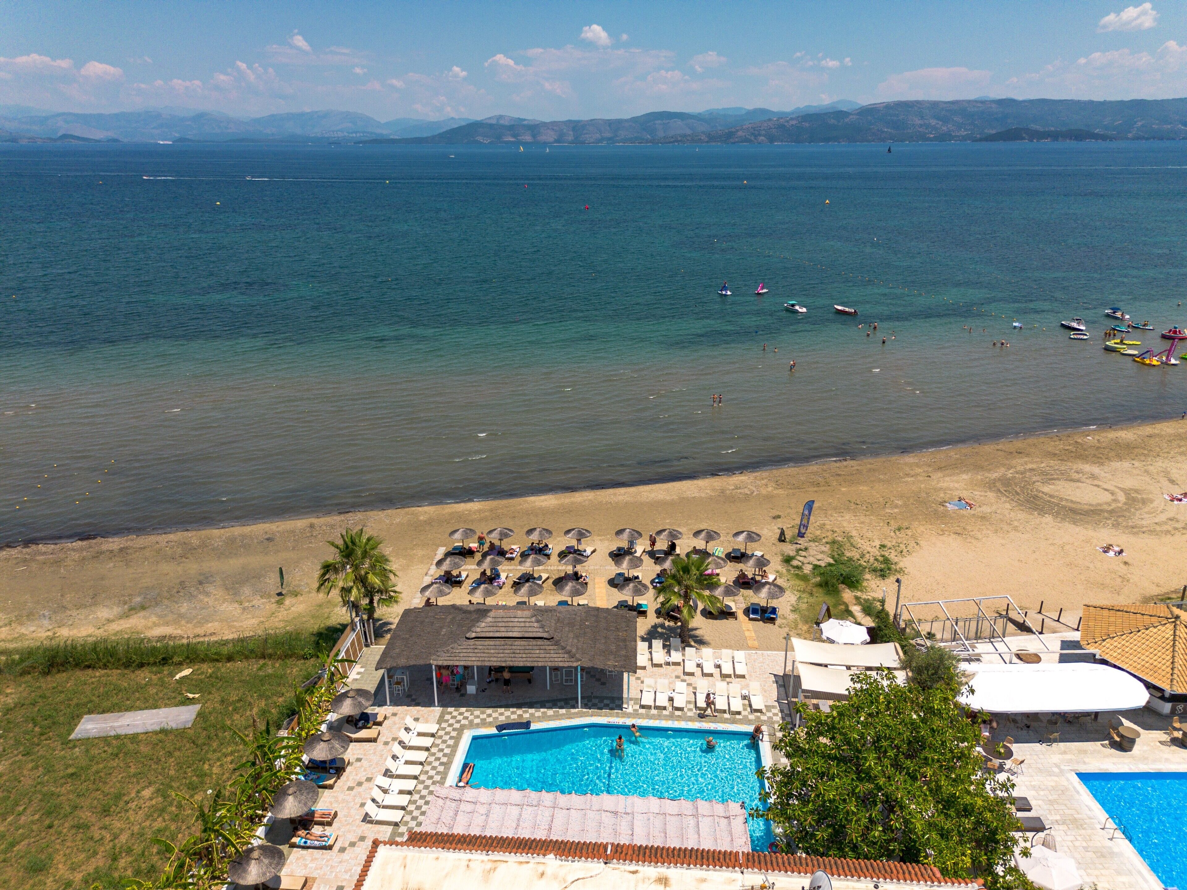 Un complexe hôtelier doté d’une piscine, d’une plage et offrant une vue sur l’océan.