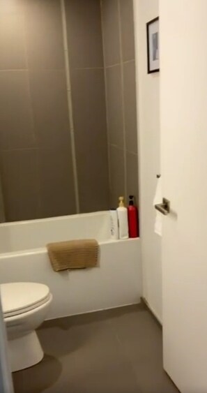 A bathroom with a toilet, a bathtub, and a shower.