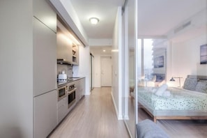 Un dormitorio moderno con una cama, una mesita de noche y un ventanal.