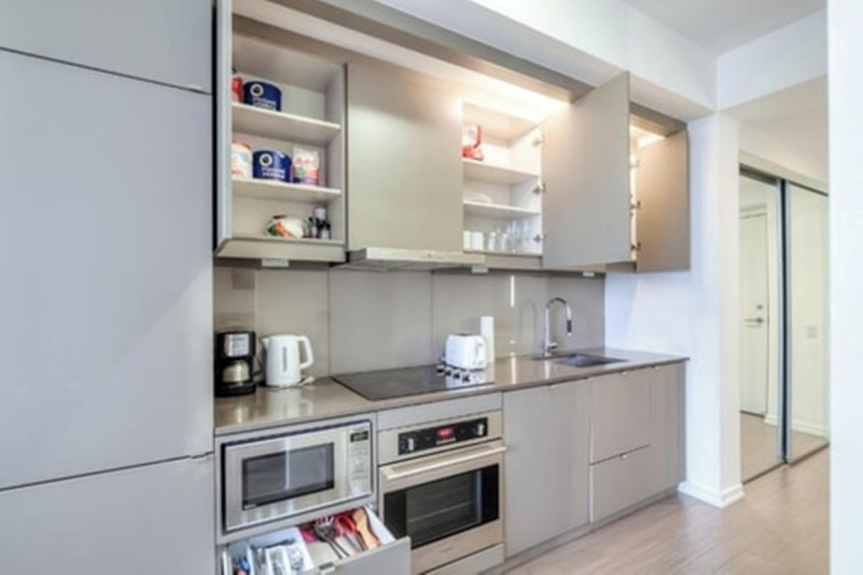 A modern kitchen with built-in appliances, a coffee maker, and a microwave.