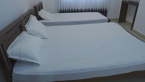 A double bed with white bedding, a wooden headboard, and a bedside table. - Green Peak View Haputale (UP)