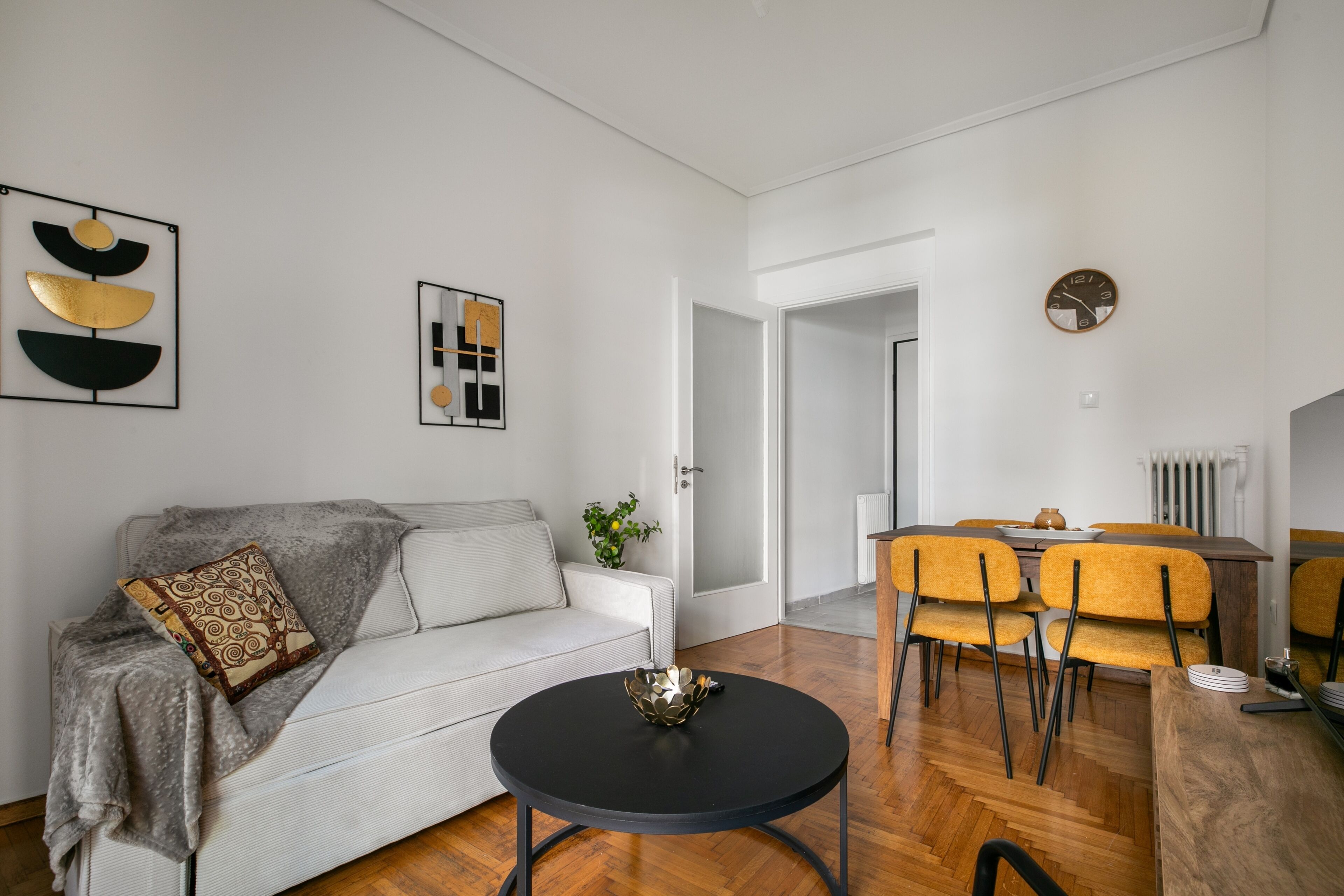 Una sala de estar moderna con un sofá, una mesa de centro y un comedor con sillas y una mesa.