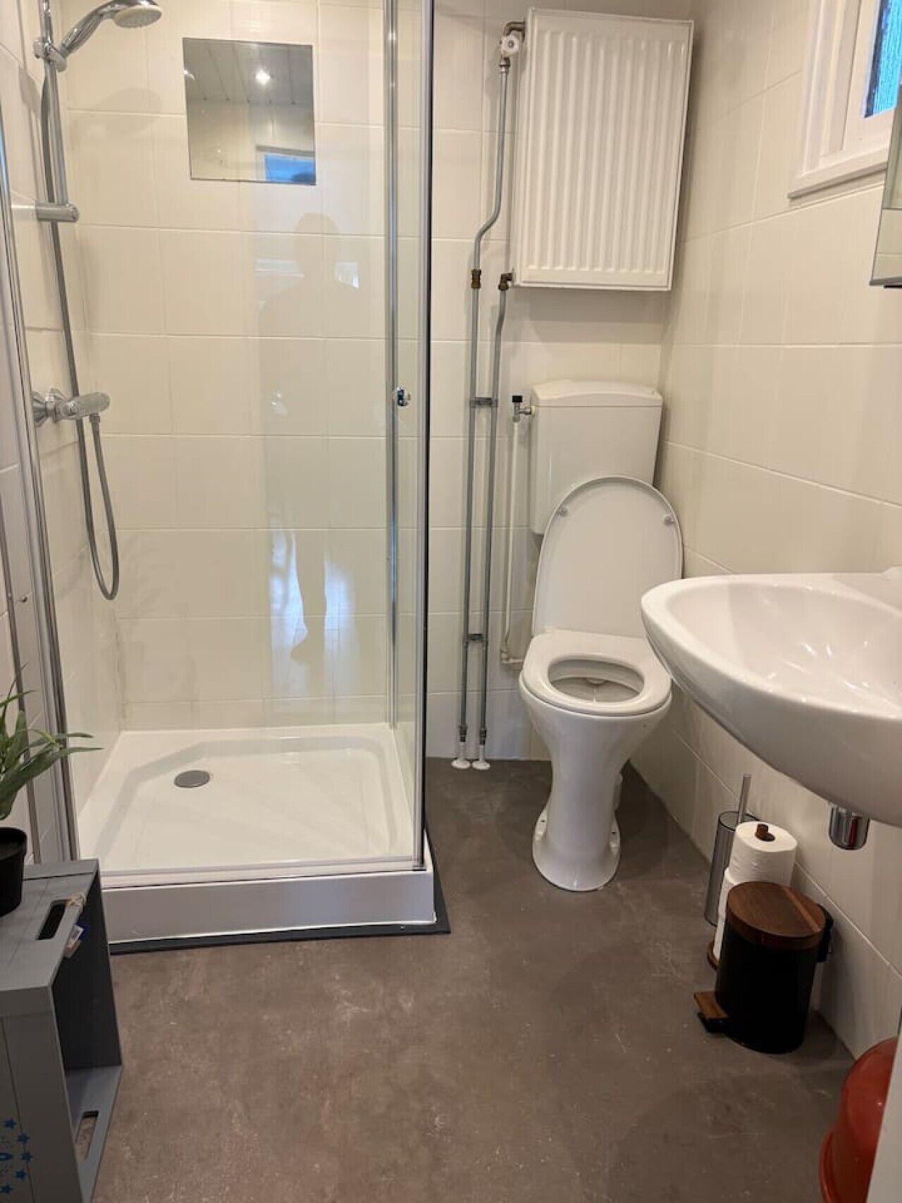 Une salle de bain avec une douche à parois de verre, des toilettes et un lavabo.