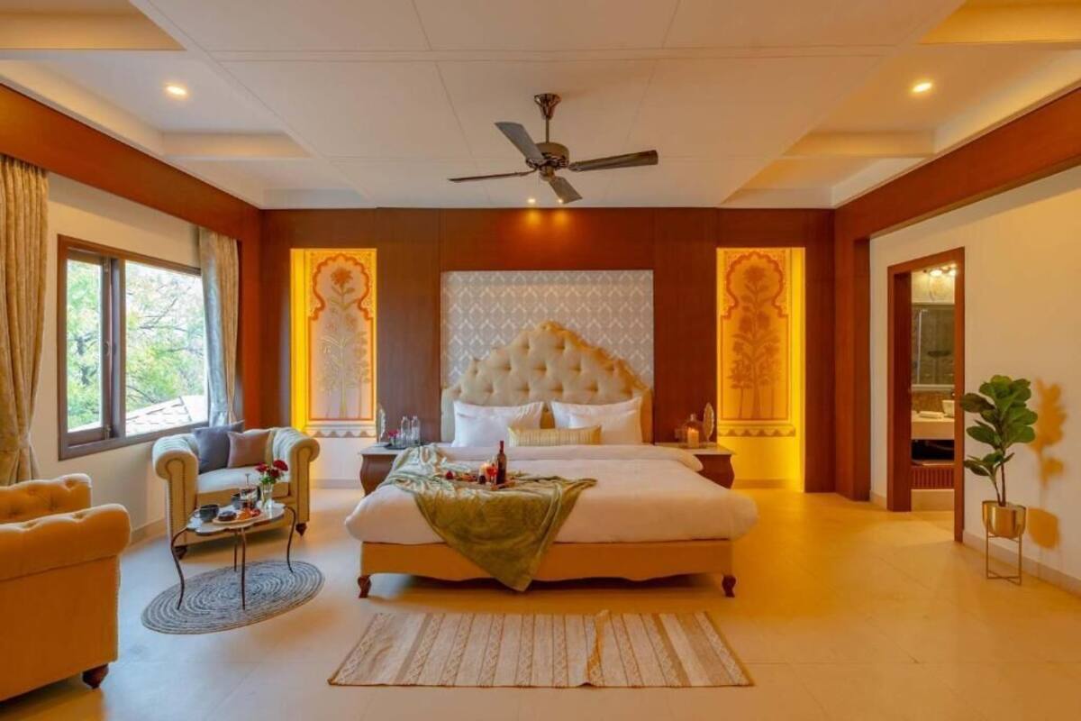 A spacious bedroom with a large bed, a ceiling fan, and a view of the outdoors.