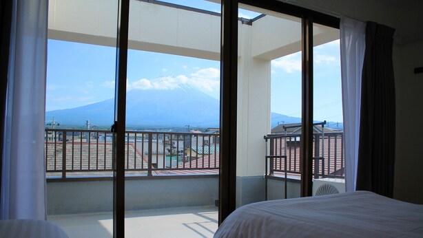 Habitación de hotel con balcón, cama y vistas a la montaña.