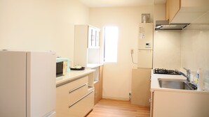 Cocina compacta con refrigerador, microondas, fregadero y estufa.