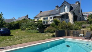 A rectangular swimming pool with a clear blue water surface, surrounded by a brick deck.