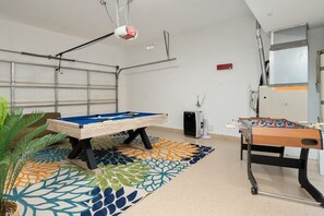 A room with a pool table, foosball table, and a projector. - The Refuge - Desert Escape w/ Pool Spa & Game Room (Desert Hot Springs)
