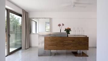 Een moderne badkamer met een houten wastafelmeubel, een douchecabine met glazen wanden en een plafondventilator.