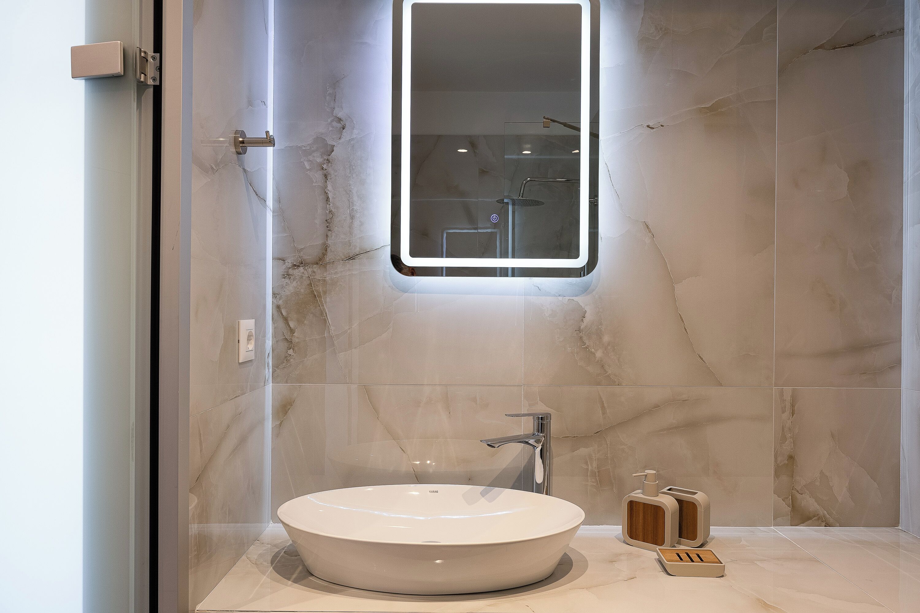 A modern bathroom with a round sink, a mirror, and a shower.