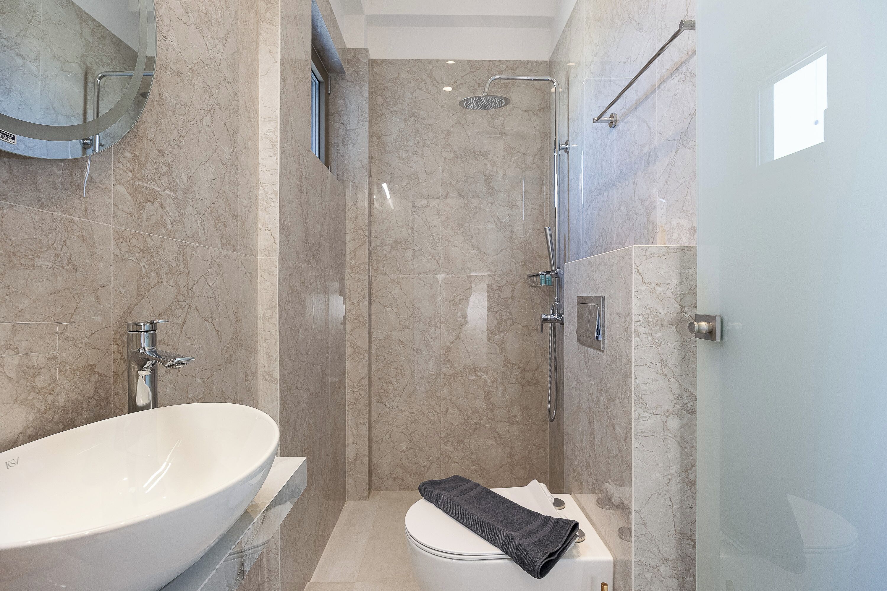 Une salle de bain avec un lavabo blanc, des toilettes et une douche.