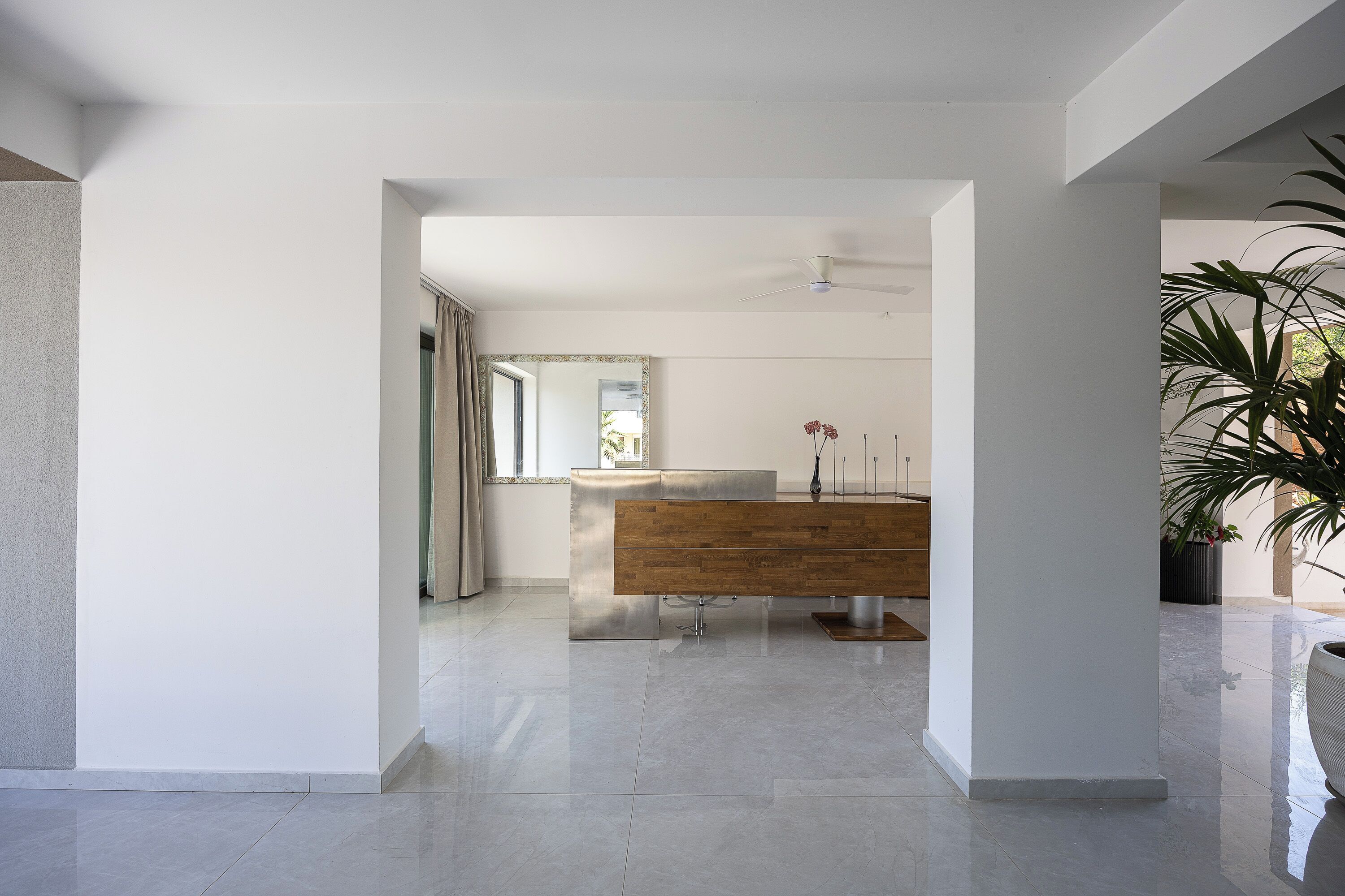 Une salle de bain moderne avec un meuble-lavabo en bois, un grand miroir et un ventilateur de plafond.