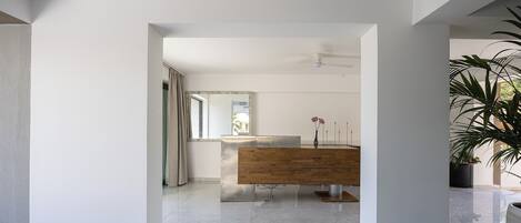 Une salle de bain moderne avec un meuble-lavabo en bois, un grand miroir et un ventilateur de plafond.
