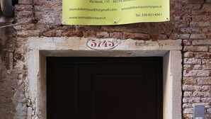 Eine braune Tür mit Zahlenschloss und einem Schild darüber.