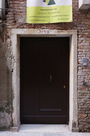 A brown door with a keypad lock and a sign above it. - Venice 2 Green (Venezia)