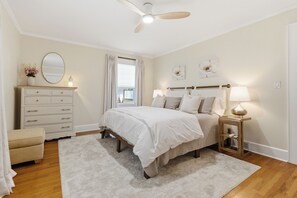 A bedroom with a bed, dresser, bedside table, and ceiling fan. - NEW! • Charming Downtown Gem • Walkable • Bike friendly (Concord)