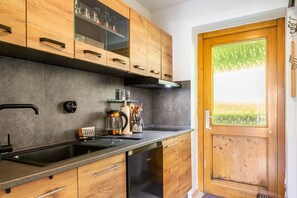 Una cocina moderna con armarios de madera, estufa integrada y lavavajillas.