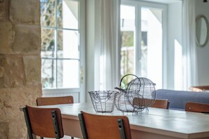 A dining area with a table, chairs, and wire baskets. - Apartment with pool near Amboise | Sleeps 4 + 1 baby (Pocé-sur-Cisse)