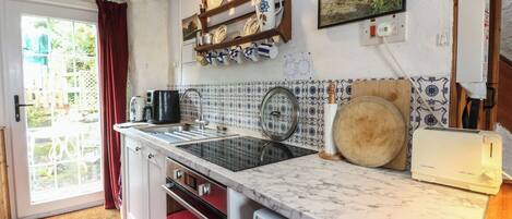A kitchen with a sink, stove, and a toaster.
