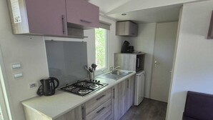 Una cocina moderna con una isla central, armarios integrados y un ventanal que aporta luz natural.