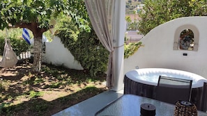 Un bain à remous avec vue sur le paysage urbain, une table avec une chaise et un hamac suspendu.