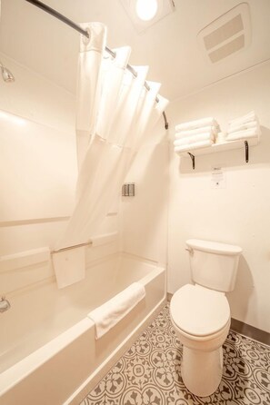 Ein Badezimmer mit Badewanne, Toilette und Duschvorhang.