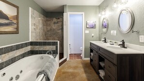 Ein Badezimmer mit Badewanne, Dusche, Waschtisch mit Spiegel und Toilette.