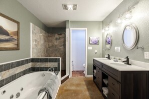 A bathroom with a bathtub, a shower, a vanity with a mirror, and a toilet. - Rustic-Modern Ranch Retreat with Fire Pit & Nature Views in Mountain Home, Texas (Mountain Home)