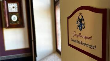 A wall with a framed clock and a sign with a logo and text.