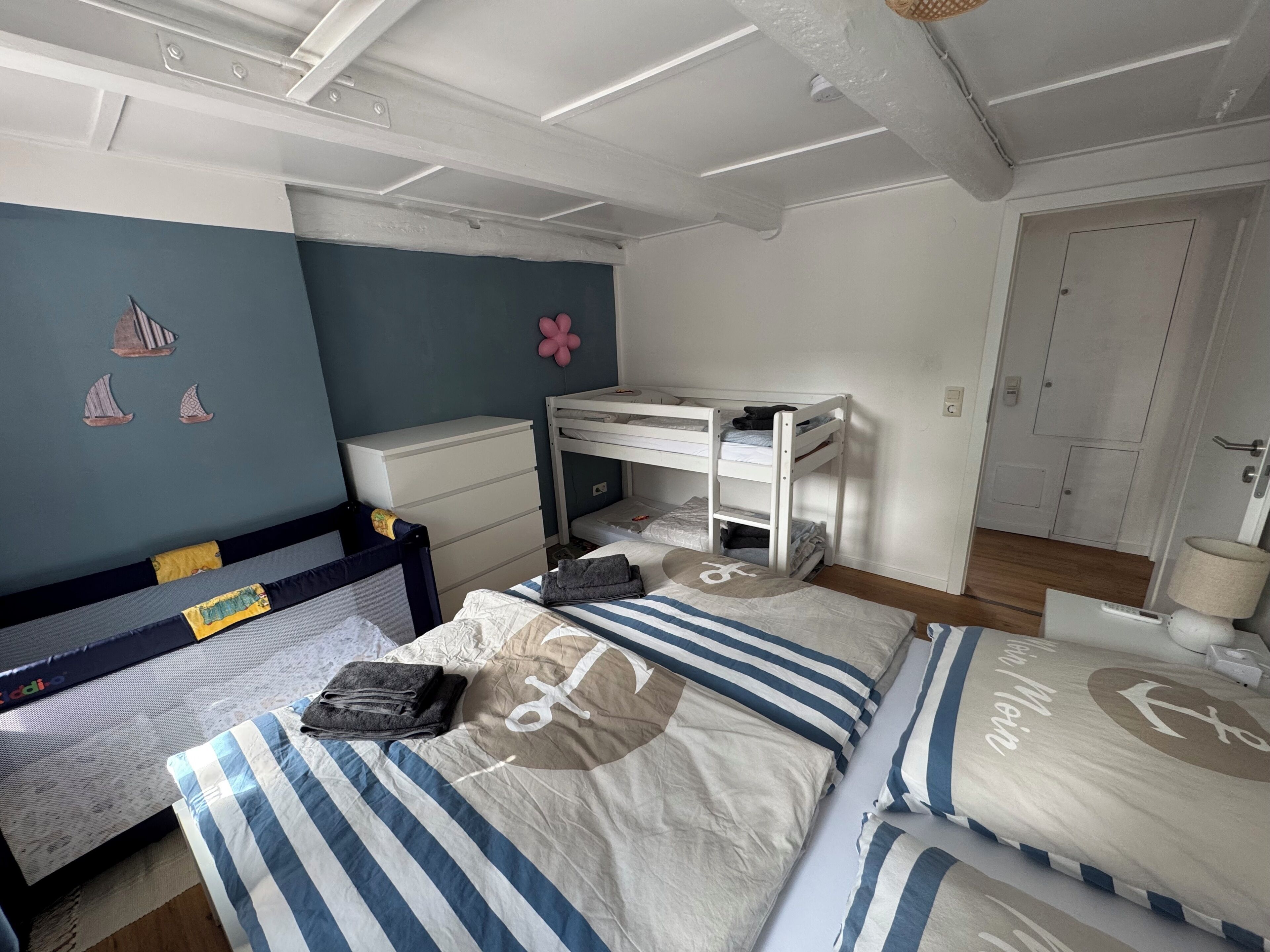 Ein Schlafzimmer mit Etagenbetten, einem Schreibtisch, einem Stuhl und einer Wand mit Dekoration.