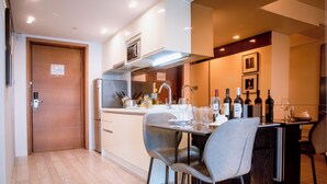 Cozinha moderna com área de jantar, equipada com geladeira, micro-ondas e pia.