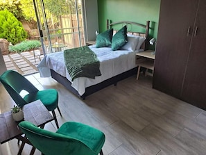Une chambre à coucher comprenant un lit, un bureau, une chaise et une armoire.