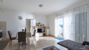 Une chambre d’hôtel moderne dotée d’un coin repas, d’une télévision et d’un balcon avec vue.