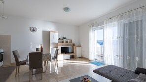 Ein modernes Hotelzimmer mit Essbereich, einem Fernseher und einem Balkon mit Blick.
