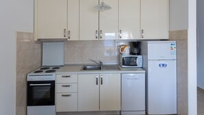 A compact kitchen with a stove, oven, microwave, and refrigerator. - Apartman Arapovic 5 by Villas Guide (Klek)