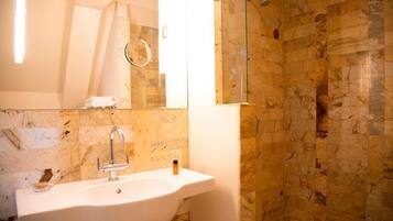 Un baño con lavabo, espejo y ducha.