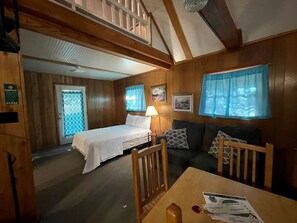 A room with a bed, a couch, a table, and a window with curtains. - Cozy Loft Cabin with Private Pond Views Near Zwolle, Louisiana (Zwolle)