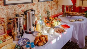 A breakfast buffet with various food items, a coffee station, and a fruit display.