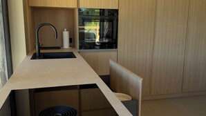 A modern kitchen with built-in appliances, a sink, and wooden cabinets.