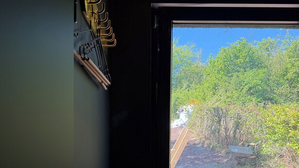 A window with a view of a forested area outside.