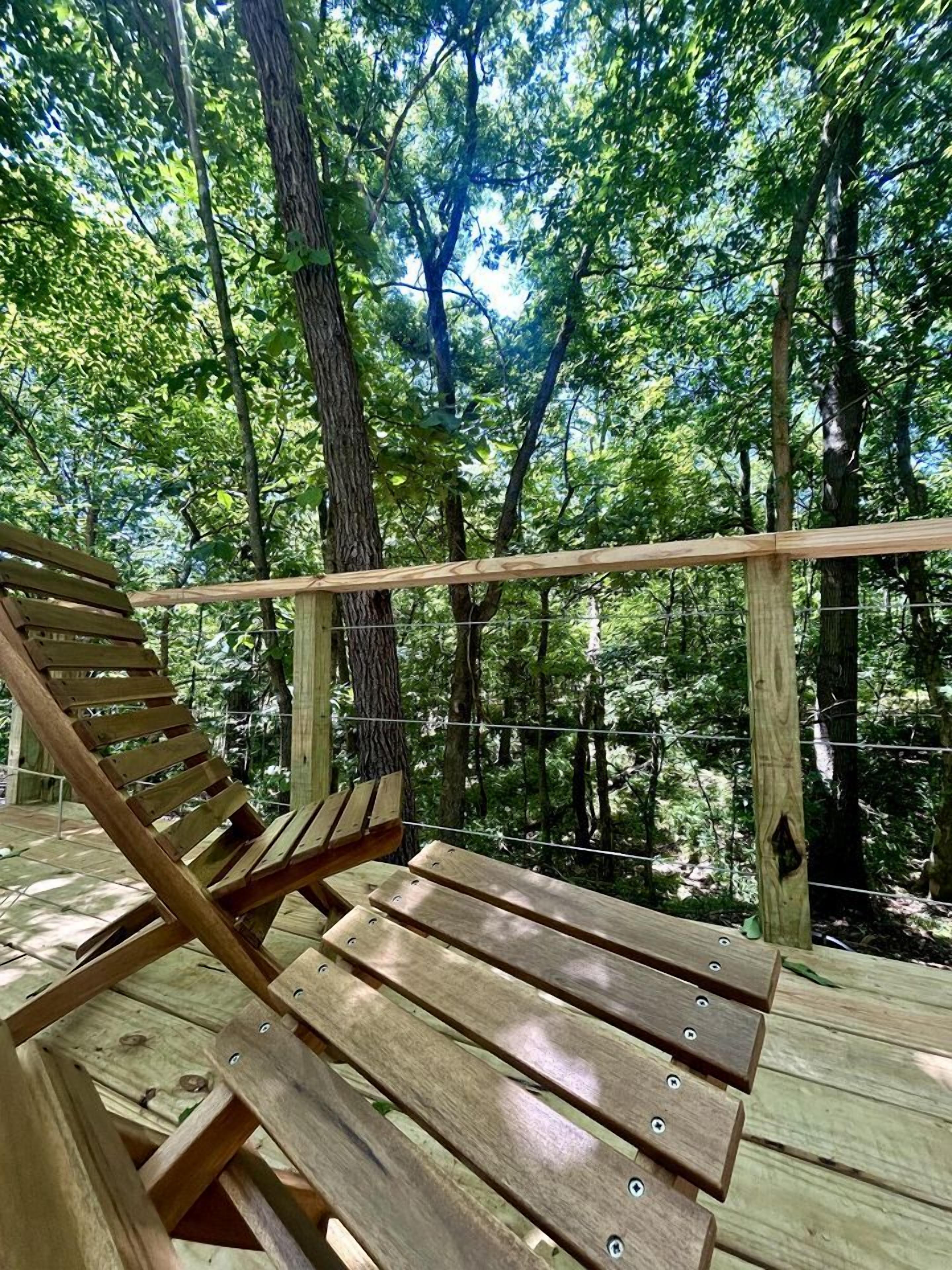 A wooden deck with a bench and a wooden railing.