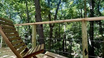 A wooden deck with a bench and a wooden railing.
